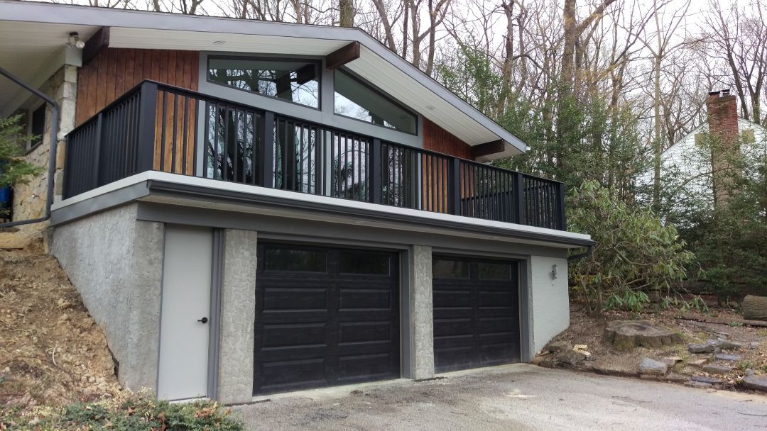 Garage with elevated deck above in Wayne
